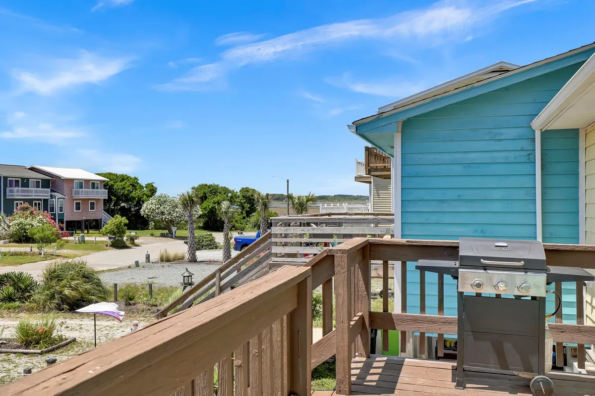 The focus here is on an inviting deck with a grill, deck railing, and views of nearby homes and greenery. The scene suggests sunny afternoons spent grilling, evenings filled with laughter, and community bonding over shared spaces, directly tying in to themes of group gatherings, morning coffees, and shared outdoor experiences.
