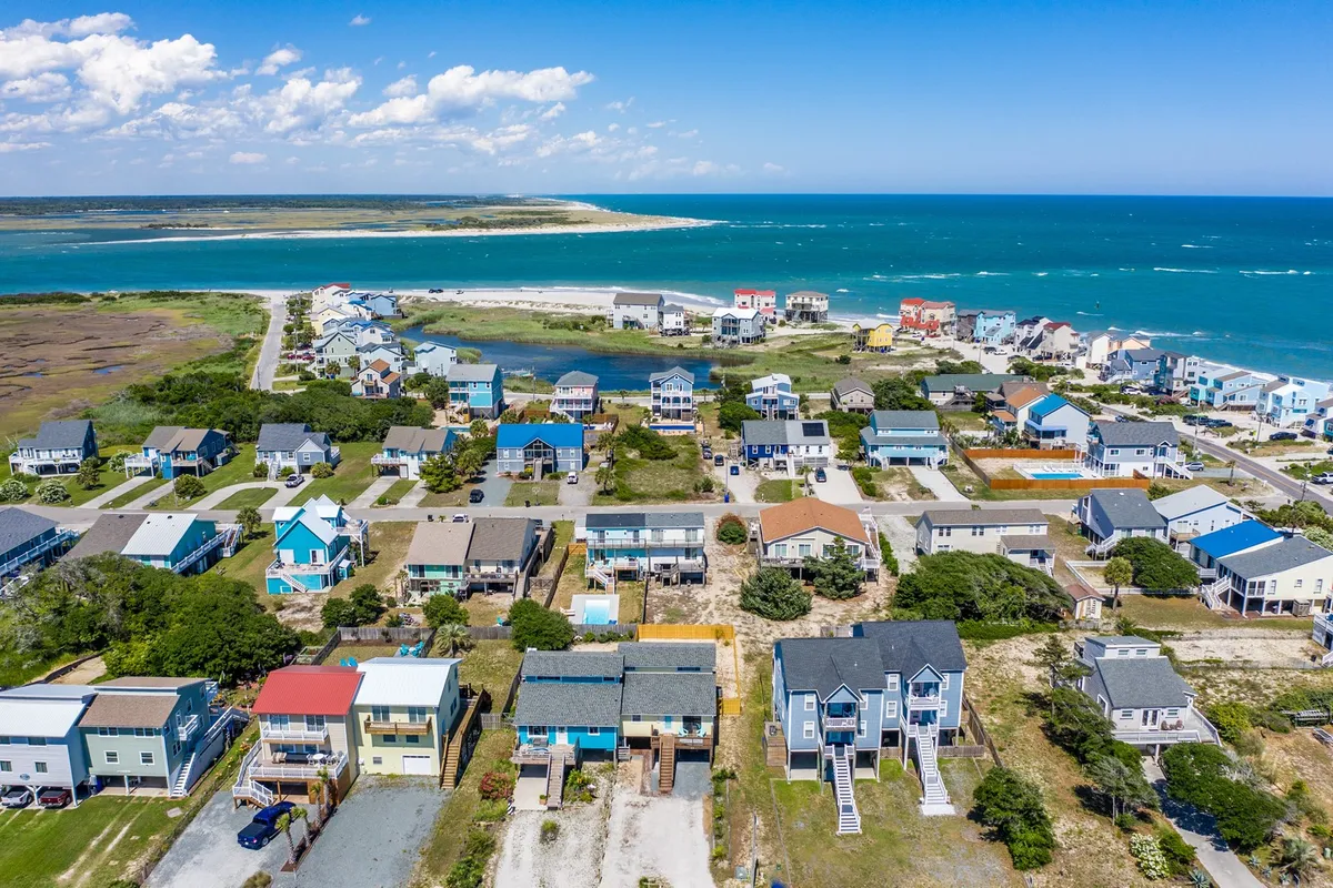 A cheerful coastal scene highlighting colorful houses, peaceful waterfront areas, a welcoming beach, and winding roads. The tranquil, open setting is ideal for imagining long, leisurely walks with pets along scenic routes.